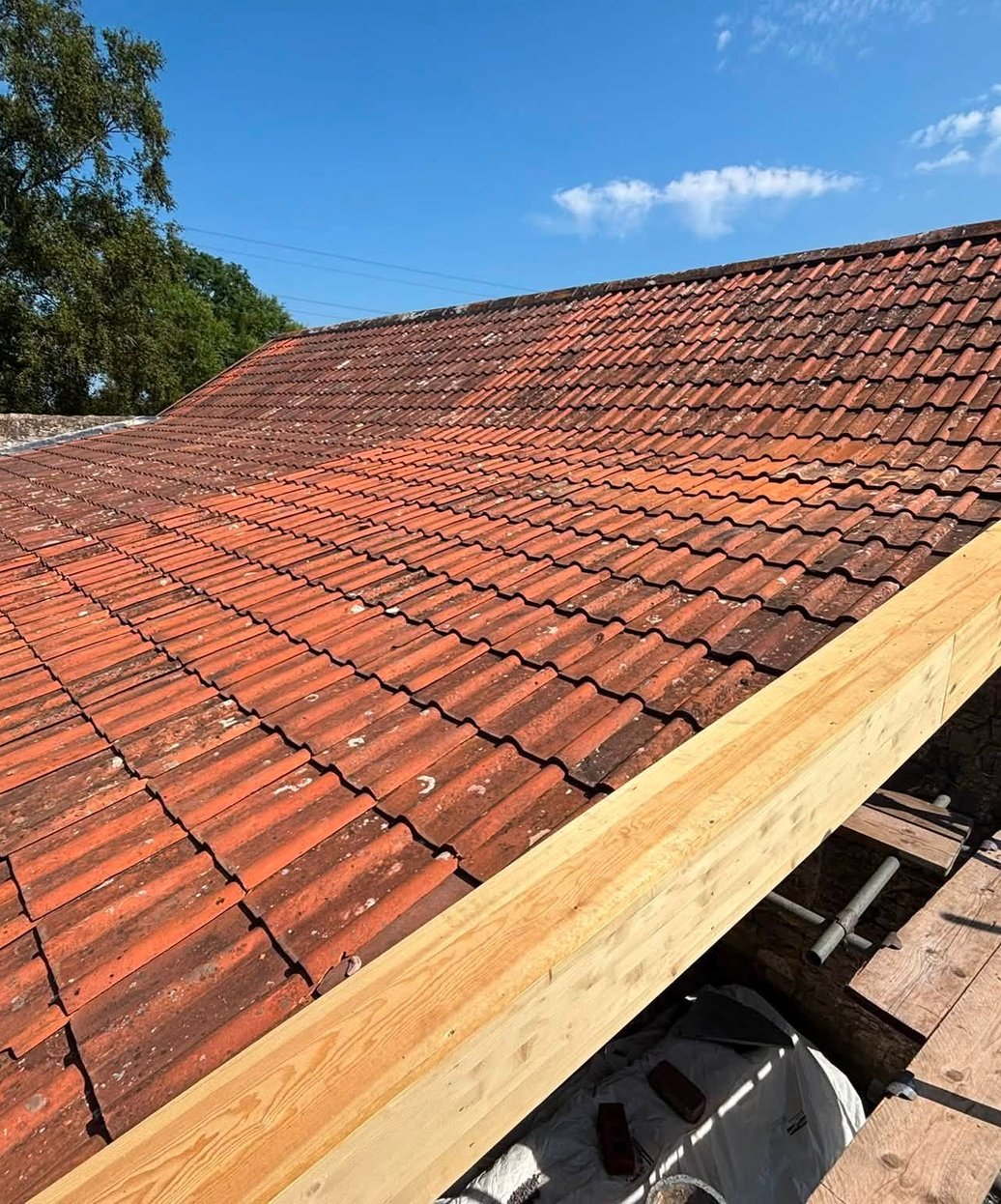 Clay tiled roof and stone wall during roofing work