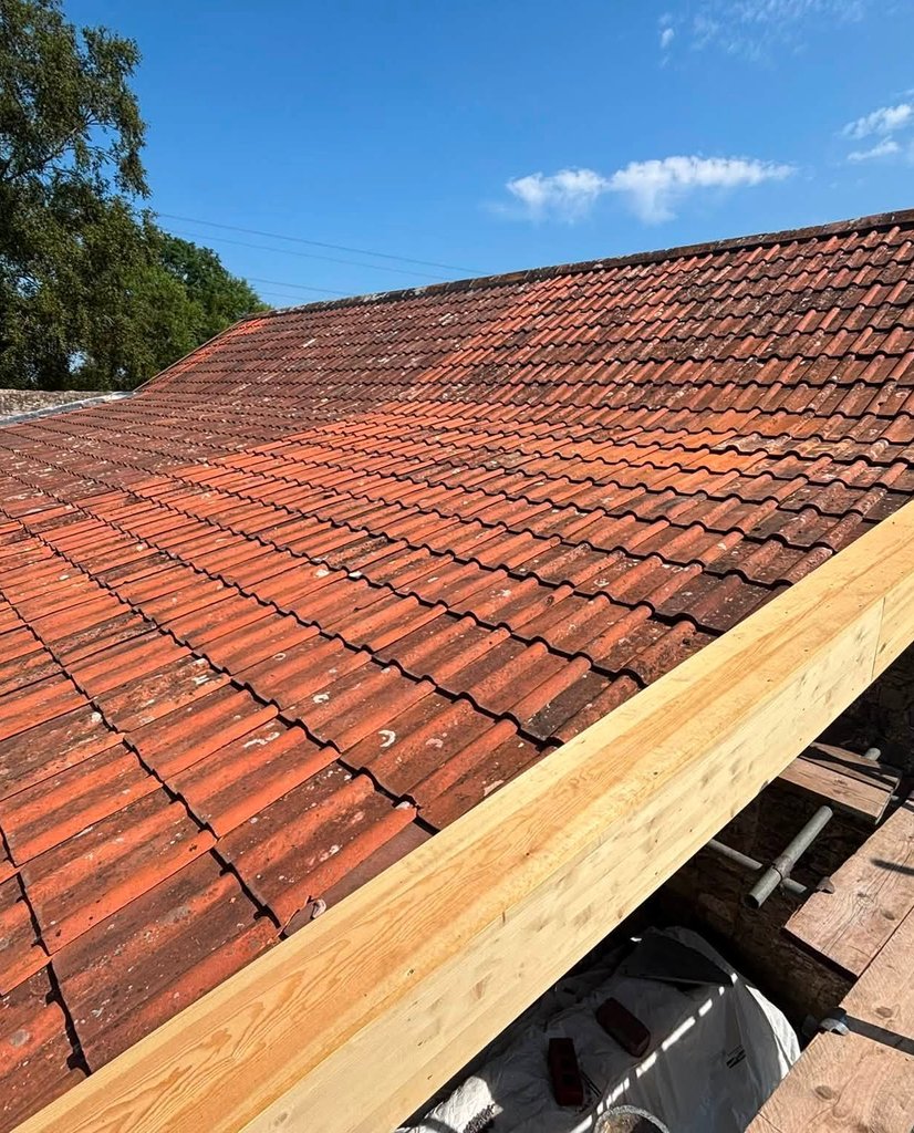 Clay tiled roof being worked on from scaffolding