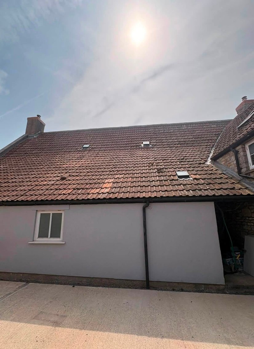 Clay tiled roof with roof windows and chimneys